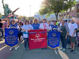Athletes, coaches, and volunteers marching proudly in the Special Olympics Parade of Champions at The Big E fairgrounds