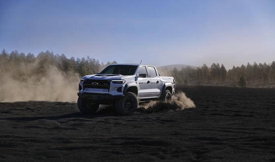 The 2024 Chevrolet Colorado ZR2 in Summit White, conquering a challenging rocky trail, showcasing its off-road dominance